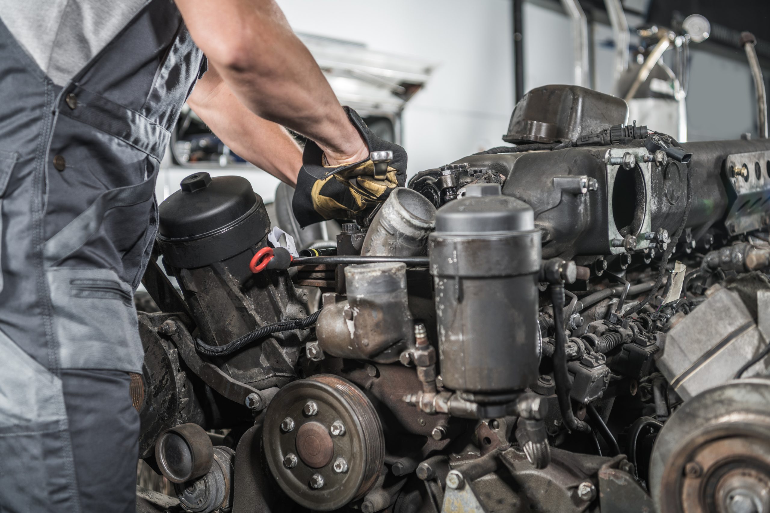 Closeup of the Truck Engine Maintenance Services. Caucasian Mechanic Doing Small Repair Works with His Combination Wrench at Local Car Shop Station.